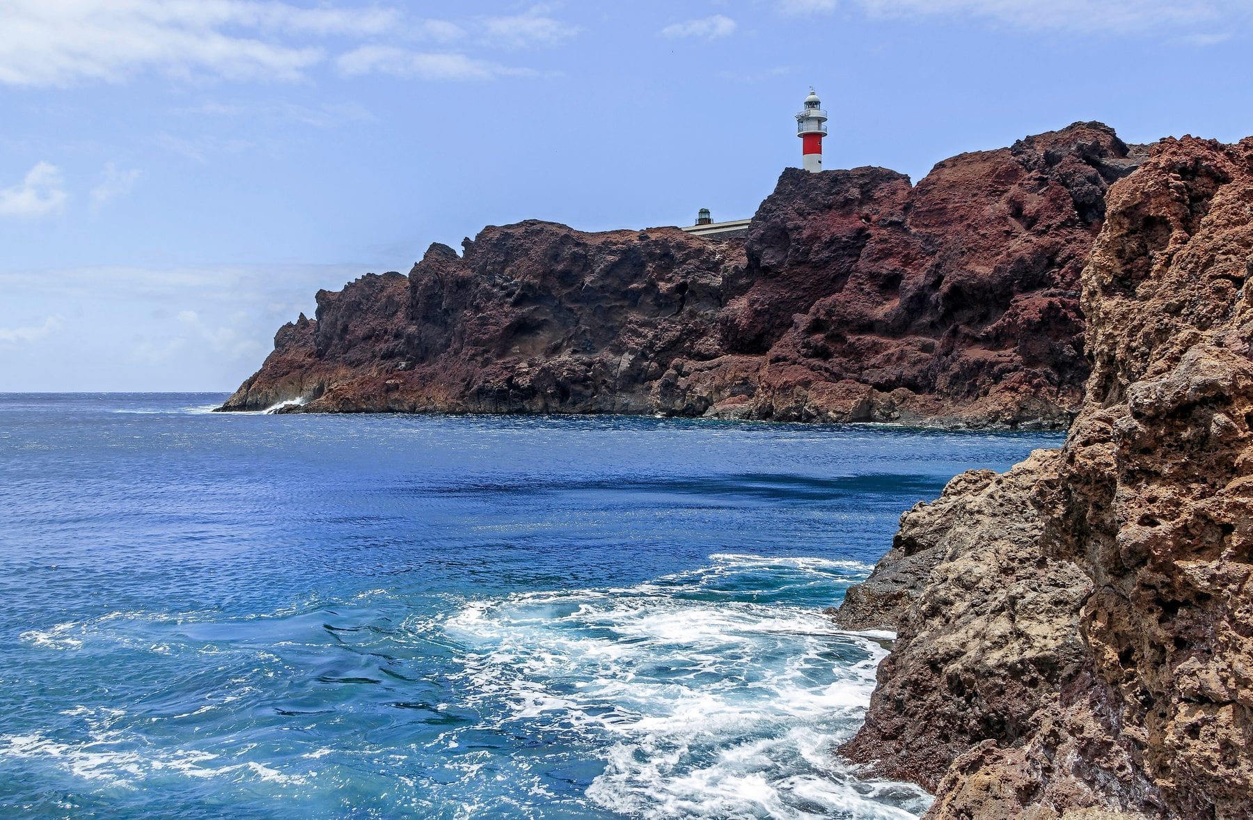 Acantilados rojizos y faro de Punta de Teno sobre el Atlántico